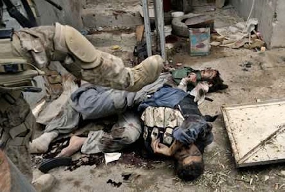 A US Marine pushes corpses of Iraqi fighters, Fallujah, Friday, November 12, 2004. Photo by Anja Niedringhaus / Associated Press