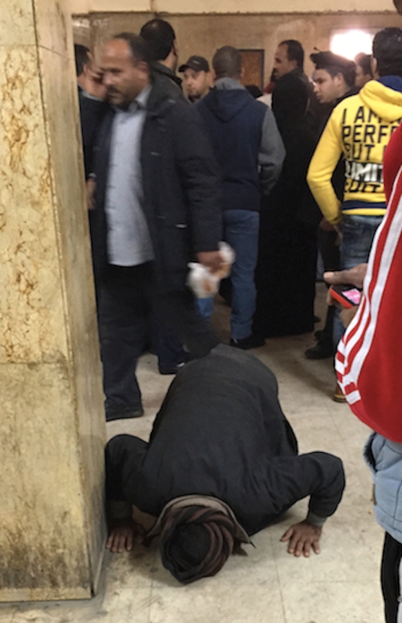 In the courthouse, a family member gives thanks for the acquittal. Photo: J. Lester Feder, BuzzFeed, at http://www.buzzfeed.com/lesterfeder/men-charged-with-debauchery-in-egypt-were-raped-in-custody-l#.suDVwMew2
